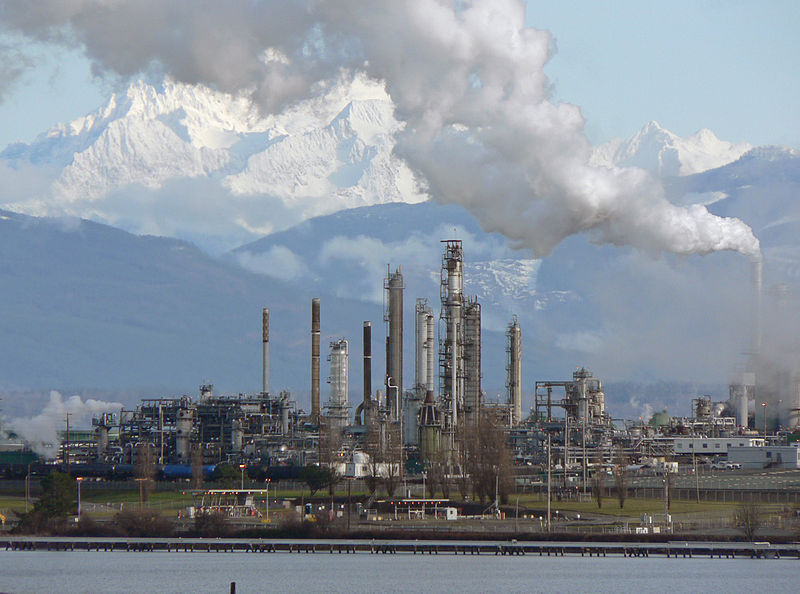 a refinery in front of snowy mountains