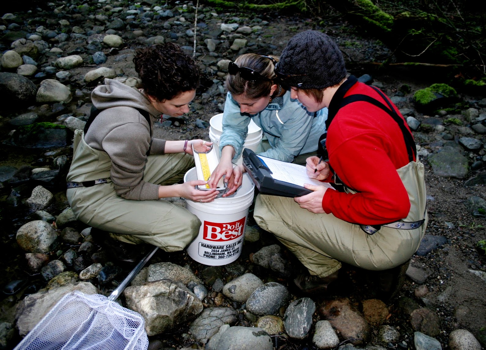 Environmental Science Students recording data and analyzing samples on a rocky river bed