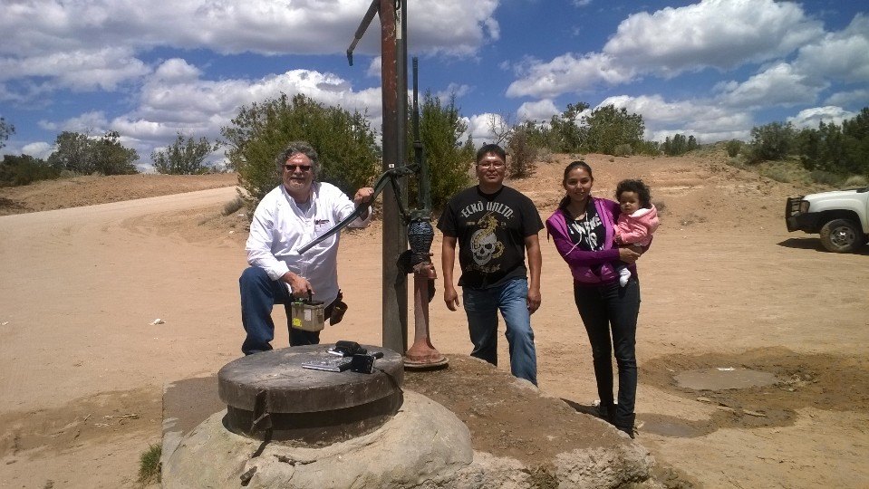 Tommy Rock and family in the dessert near a water pump