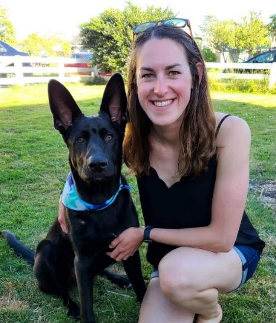 Dana Flerchinger squats down, posing with a dog with large ears