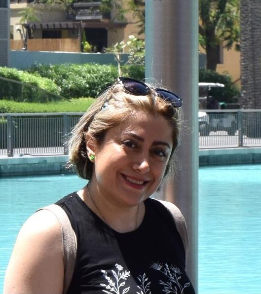 Yashel Kakavand poses in front of a pool