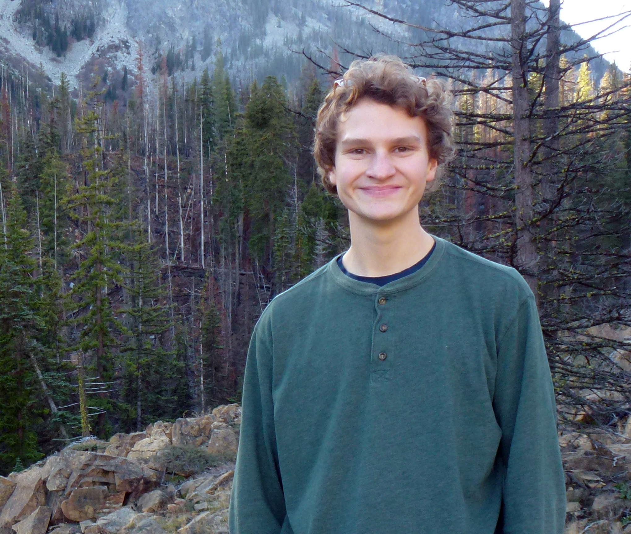 Portrait of Tim Anderson standing in the woods wearing a dark green thermal