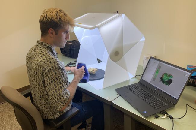 Jack McBride scans a monkey skull using a 3-d scanner as the image is shown on his laptop